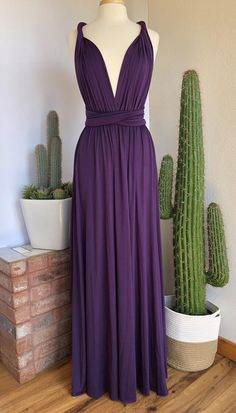 a dress is shown on a mannequin next to cacti and succulents