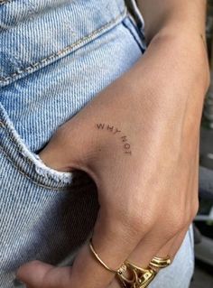 a person with a small tattoo on their left hand and the word love is written in cursive writing