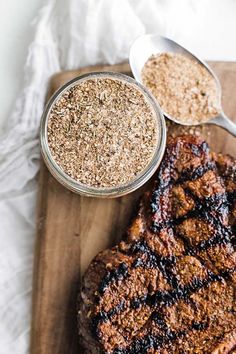 steak and spices on a cutting board next to a glass jar with powdered sugar