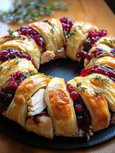 a cranberry and chicken crescent bread on a black plate with rosemary sprigs