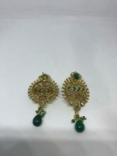 Vintage Indian wedding style button stud earrings Main stone Green emerald and white sapphire Over an inch long Lovely handmade silver work with gold finish 92.5% Sterling Silver All jewelry is shipped in a nice gift box. Check out our over a THOUSAND great reviews Green Hand Set Bridal Earrings As Gift, Green Hand-set Bridal Earrings As Gift, Festive Green Gemstone Bridal Earrings, Green Gold Plated Round Earrings, Green Gold-plated Round Earrings, Green Round Gold-plated Earrings, Green Hand Set Earrings For Gift, Green Hand-set Earrings For Gift, Elegant Green Bridal Earrings With Intricate Design