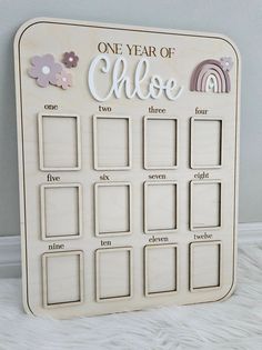 a wooden calendar with the words one year of chaos written on it and flowers in front