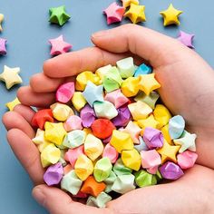 a person holding out their hand full of colorful stars