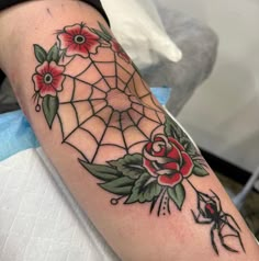 a spider and rose tattoo on the arm