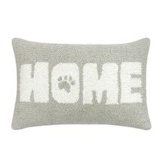 a pillow with the word home written in white on it and a dog's paw