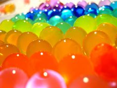 there are many different colored balloons on the table together, and one is in color