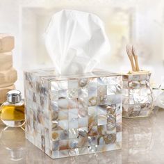 a tissue dispenser sitting on top of a counter next to other items