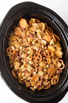 a black crock pot filled with chex mix