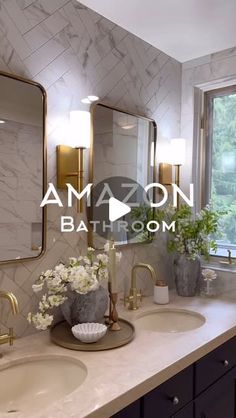 a bathroom with marble counter tops and two sinks in front of large mirrors, surrounded by gold accents