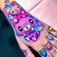 a woman's hand with tattoos on it and an image of a pink bear