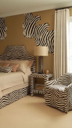 a zebra print bedroom with two chairs and a bed