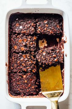 a close up of a spoon in a casserole dish with chocolate and nuts