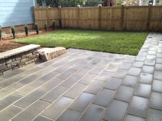 a brick patio in front of a wooden fence