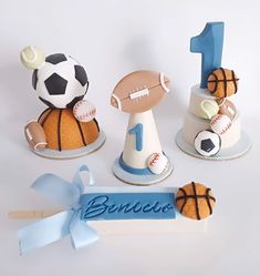 three cakes made to look like sports balls and basketballs with the number one on top