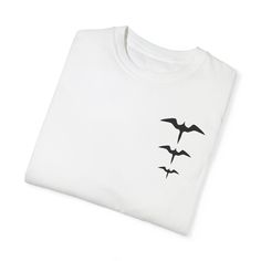 This iwa bird shirt features 3 different size iwa bird silhouettes where a pocket would normally be on the shirt. The iwa bird or great frigate bird is a very popular bird for designs in Hawai'i. We love the comfort colors brand shirts that the design is printed on. If you like the oversized tee shirt fit, please size up when you order. Made of 100% ring-spun US cotton, this soft-washed, garment-dyed t-shirt brings extra coziness to your wardrobe. The relaxed fit, and double-needle stitching make for a comfortable but durable t-shirt that is perfect for daily wear. The design is printed directly on the garment so colors may differ depending on t-shirt color and may also differ from the colors on your screen. All of our designs have been created by a member of our shop. Comfort Colors 1717 Casual Crew Neck T-shirt With Bird Print, Frigate Bird, Bird Silhouettes, Oversized Tee Shirt, Bird Shirt, Comfort Colors Tshirt, Bird Silhouette, Design Tshirt, Brand Shirts