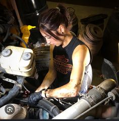 a woman working on an engine in a garage