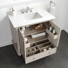 a white sink sitting under a bathroom mirror next to a counter top with drawers underneath it