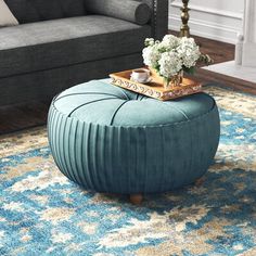 a blue ottoman sitting on top of a rug