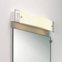 a bathroom mirror mounted to the side of a wall with an electronic light on it