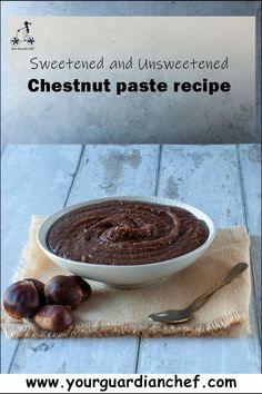 a white bowl filled with chocolate paste next to some nuts