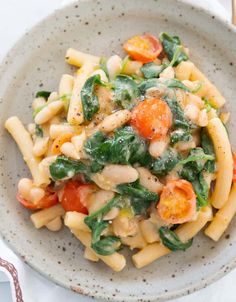 a white bowl filled with pasta and vegetables