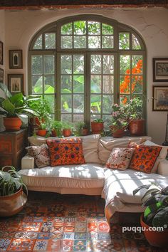 a living room filled with furniture and lots of plants in front of a large window