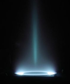 a black background with a blue and green light coming from the top, in the dark