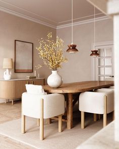 an image of a dining room setting with white chairs and a wooden table in the center