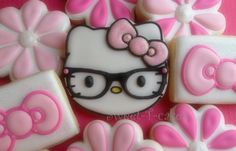 hello kitty cookies are decorated with pink and white icing, along with flower decorations