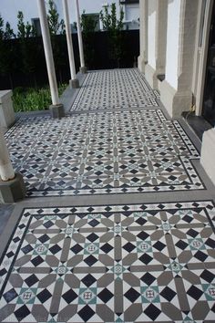 an outdoor walkway with black and white tiles