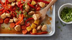 a pan filled with chicken, peppers and onions