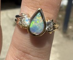 This stunning ring is a true beauty. With a pear-shaped opal as the main stone, it boasts a total of 18k yellow gold and features a bezel setting style. The ring is adorned with two diamonds and one additional gemstone, making it a perfect accessory for any occasion. The multicolor of the stones adds to its charm, and the 18k gold purity ensures its durability. This ring is available in size 6 and is ideal for anyone who loves yellow gold and beauty-themed jewelry. Free shipping! Please feel free to ask any questions Diamonds Ring, Themed Jewelry, True Beauty, Bezel Setting, Earings Piercings, Pear Shaped, Diamond Rings, Piercings, Pear