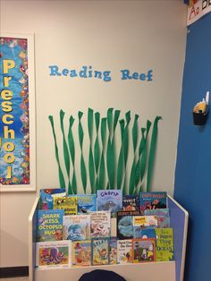 there is a book shelf with books on it and seaweed growing out of the top