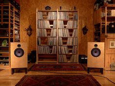 there are two speakers in front of the bookshelf and an area rug on the floor