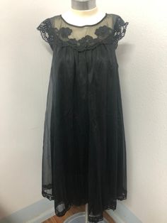 This is a beautiful black nightgown. Label reads Vanity Fair size XS (Extra Small) material is tricot all nylon exclusive of decorations and that the lingerie was made in the USA.  It has tiny flower blossoms along the neckline as decorations.  There is very little wear in the fabric, it's soft and in excellent condition. Black Lace Patchwork Dress For Daywear, Coquette Sleeveless Nightgown For Party, Black Lace Trim Dress For Wedding Night, Black Lace Dress For Wedding Night, Black Wedding Night Dress With Lace Trim, Sheer Lace Nightgown For Party, Sheer Nightgown For Party, Sheer Lace Party Nightgown, Black Lace Trim Sleepwear For Summer