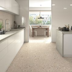 an open kitchen with white cabinets and counter tops, along with a dining room table in the background