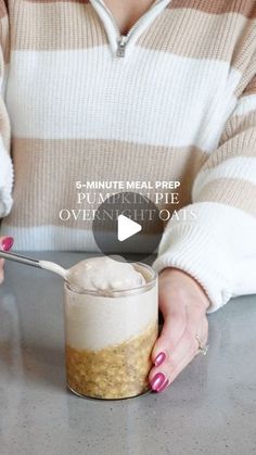 a woman is holding a spoon over a jar of oatmeal