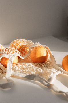 some oranges are laying on a white table