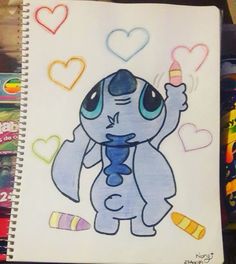 a drawing of an elephant with hearts and candy on it's face, next to some crayons