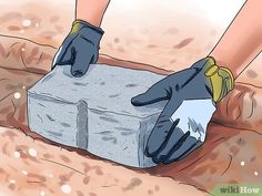 a person wearing gloves and gardening gloves is placing cement in the ground with their hands