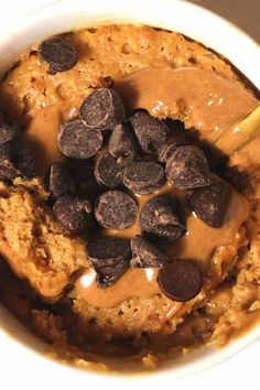 a bowl filled with oatmeal, chocolate chips and caramel sauce on top