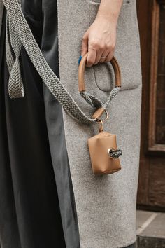 a woman is holding a purse with a strap around her waist