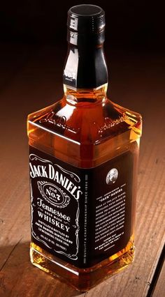 a bottle of jack daniels whiskey sitting on top of a wooden table