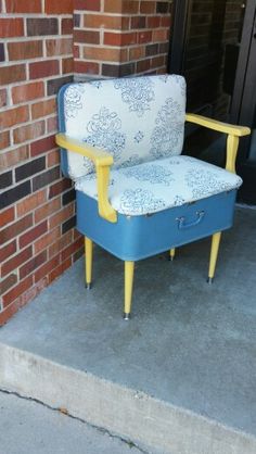 a blue and yellow chair sitting in front of a brick building