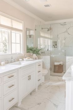 a white bathroom with two sinks and a shower