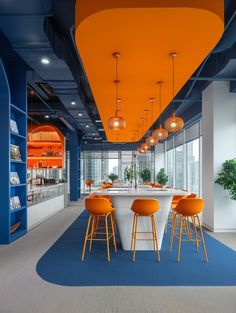 an office with blue and orange walls, white counter tops and yellow bar stools