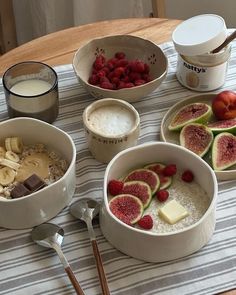 there are many different bowls on the table with fruit and milk in them, including bananas, strawberries, raspberries