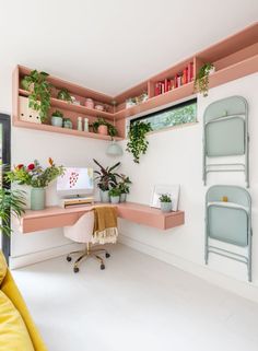 a room with some plants on shelves and a chair in front of the desk area