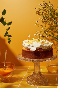 a cake sitting on top of a glass plate next to a vase filled with flowers