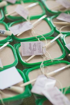 several toothbrushes are on display in green trays with tags and twine